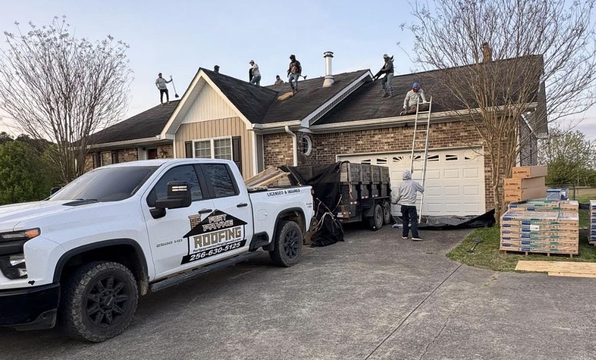 A roofer stripping old shingles down to the deck
