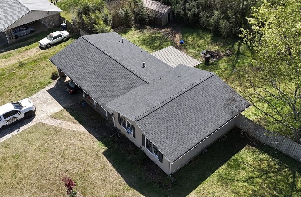 Roofer carrying a bundle of shingles up a roof
